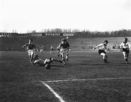 Ladies Soccer West Germany England 1957 The goalkeeper of a West German ladies soccer team goes down in all-out effort to prevent score but the ball rolls through for a goal, Nov. 3, 1957. Moving in are Mary Bee, left, and Margaret Hilton of British team which won match, 4-0, for the European Ladies Soccer Championship in West Berlin, Germany. (AP Photo)