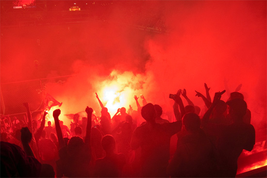 inside-section8-flares A guttural roar went up in unison with the flares lighting up the Harlem End of the stadium. Numerous individual wildfires up and down the stands came together in an instant, the darkness dissipated, the noise and the smoke and the bright bright lights firing up the supporters packed into Section 8.